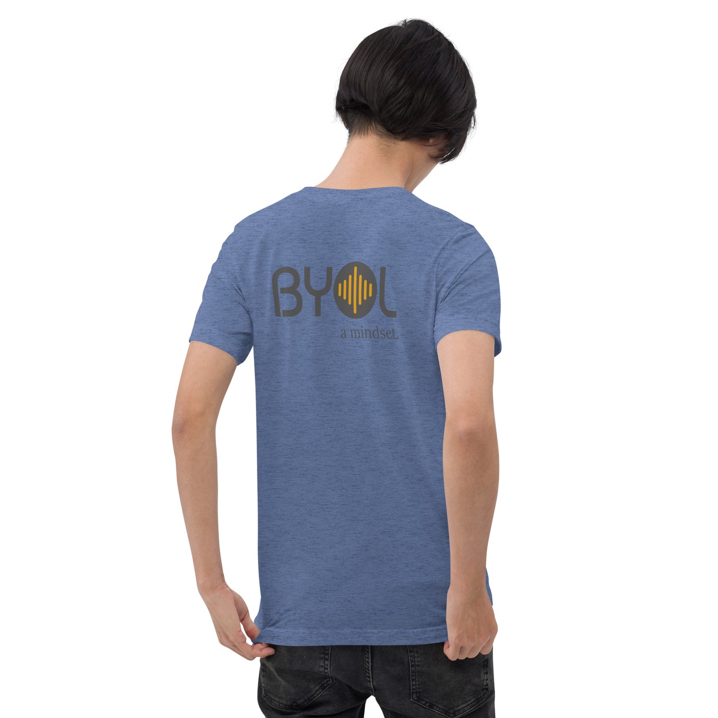 A young man with short black hair wearing a blue tri-blend "BYOL: a mindset" T-shirt, viewed from the back. The T-shirt features the "BYOL" logo in black and yellow on the back and is available in multiple colors (black, red, gray, pink, gold, plus more) and sizes (S-3XL). The "be you out loud" logo is displayed at the top.