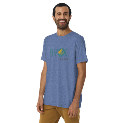 A young man with short dark hair and a beard wearing a blue tri-blend "BYOL: a mindset" T-shirt, smiling and standing with his arms at his sides. The T-shirt features the "BYOL" logo in teal and is available in multiple colors (black, red, gray, pink, yellow, plus more) and sizes (S-3XL). The "be you out loud" logo is displayed at the top.