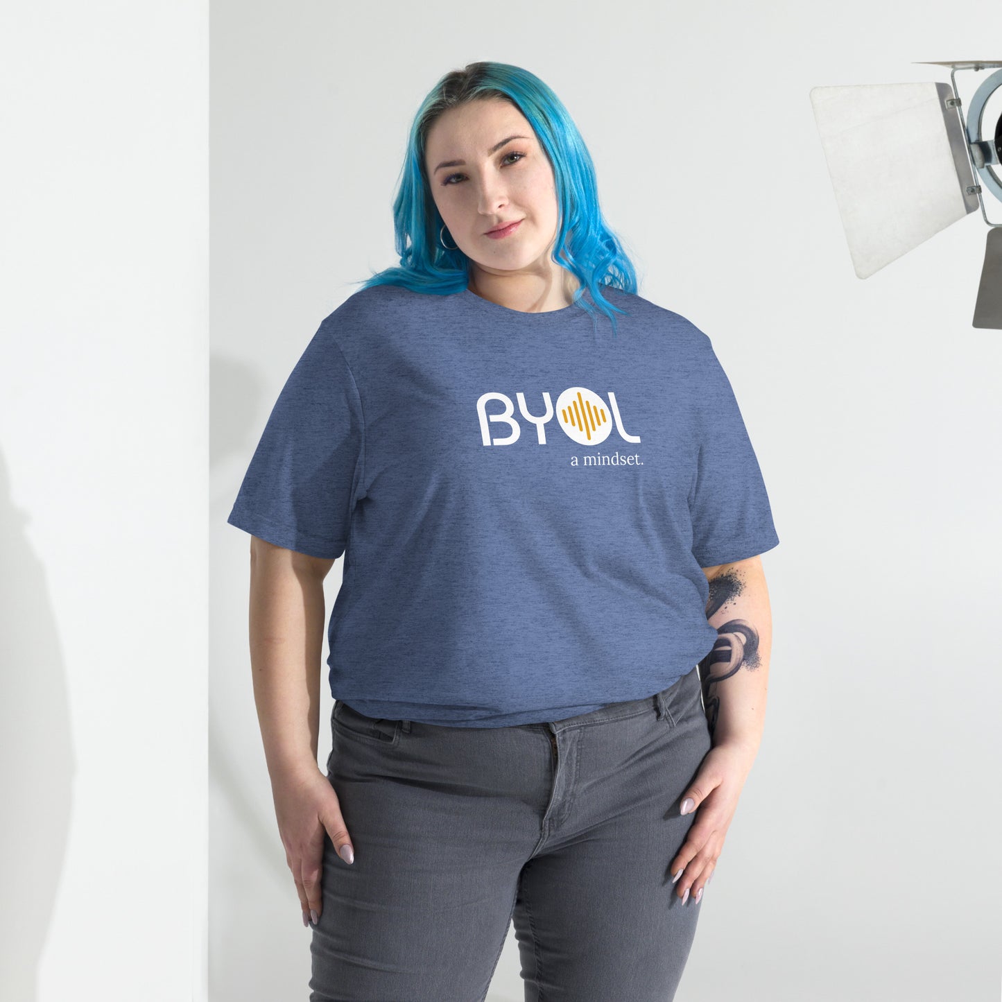 Woman wearing a loose fit BYOL mindset t-shirt in blue triblend with color options in black, red, pink, gray, and yellow, available in sizes S to 3XL.