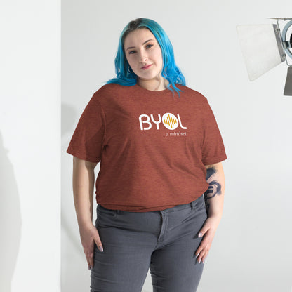 Woman wearing a loose fit BYOL mindset t-shirt in clay triblend with color options in black, red, pink, gray, and yellow, available in sizes S to 3XL.