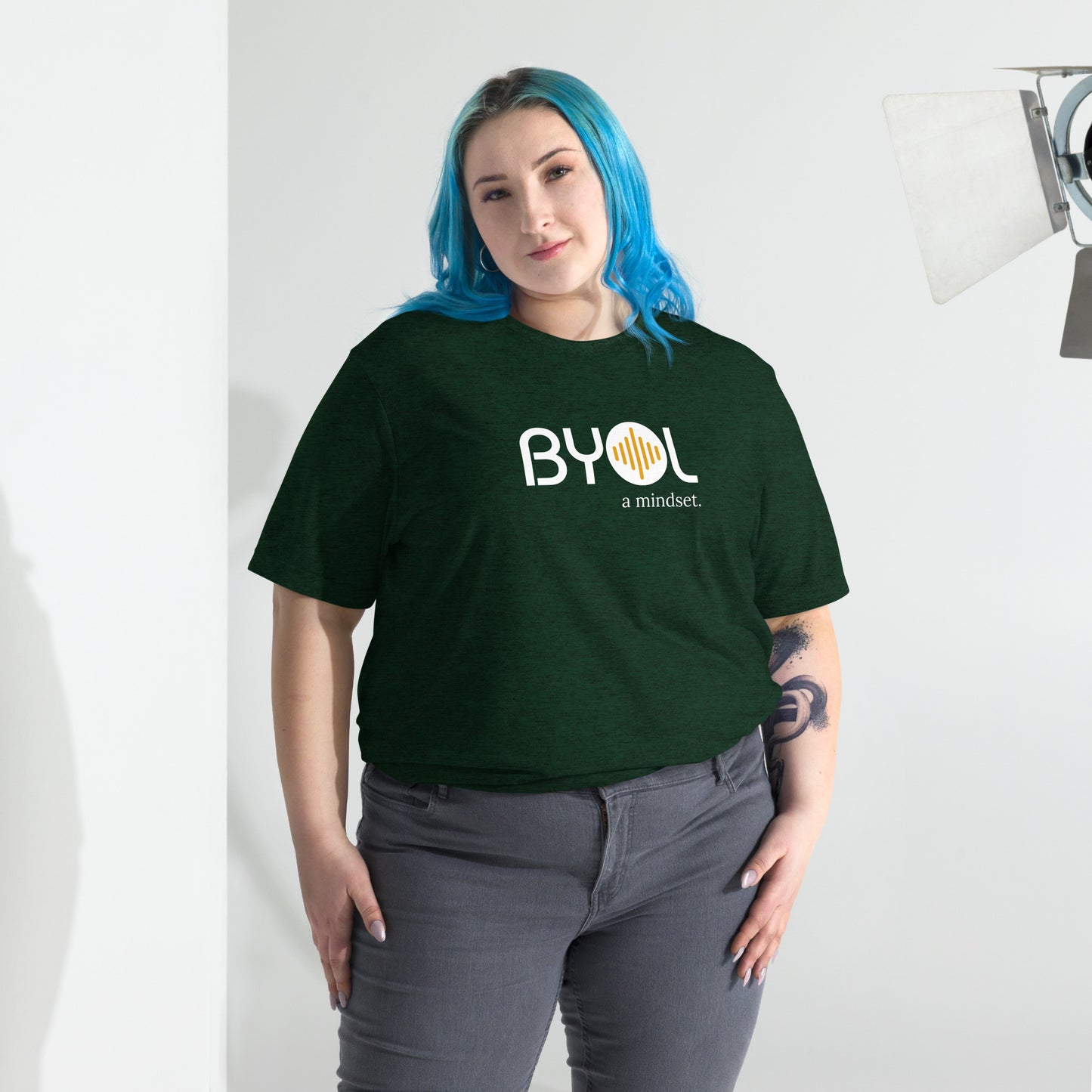 Woman wearing a loose fit BYOL mindset t-shirt in emerald triblend with color options in black, red, pink, gray, and yellow, available in sizes S to 3XL.