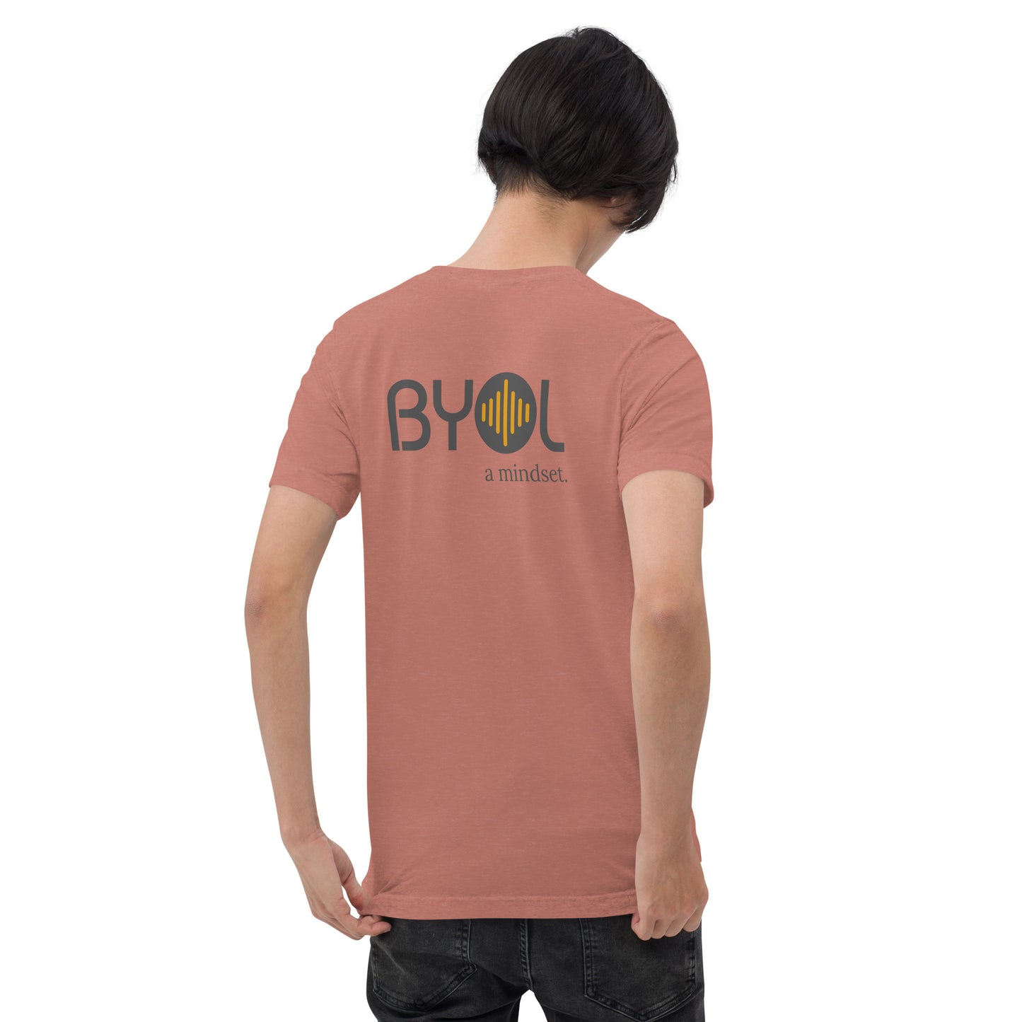 A young man with short black hair wearing a mauve tri-blend "BYOL: a mindset" T-shirt, viewed from the back. The T-shirt features the "BYOL" logo in black and yellow on the back and is available in multiple colors (black, red, gray, pink, gold, plus more) and sizes (S-3XL). The "be you out loud" logo is displayed at the top.