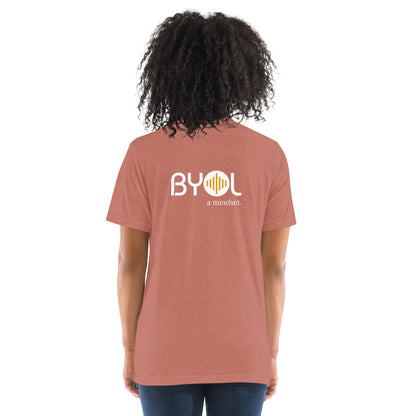 Back view of a woman wearing a mauve triblend BYOL mindset t-shirt with color options in black, red, pink, gray, and yellow, available in sizes S to 3XL.