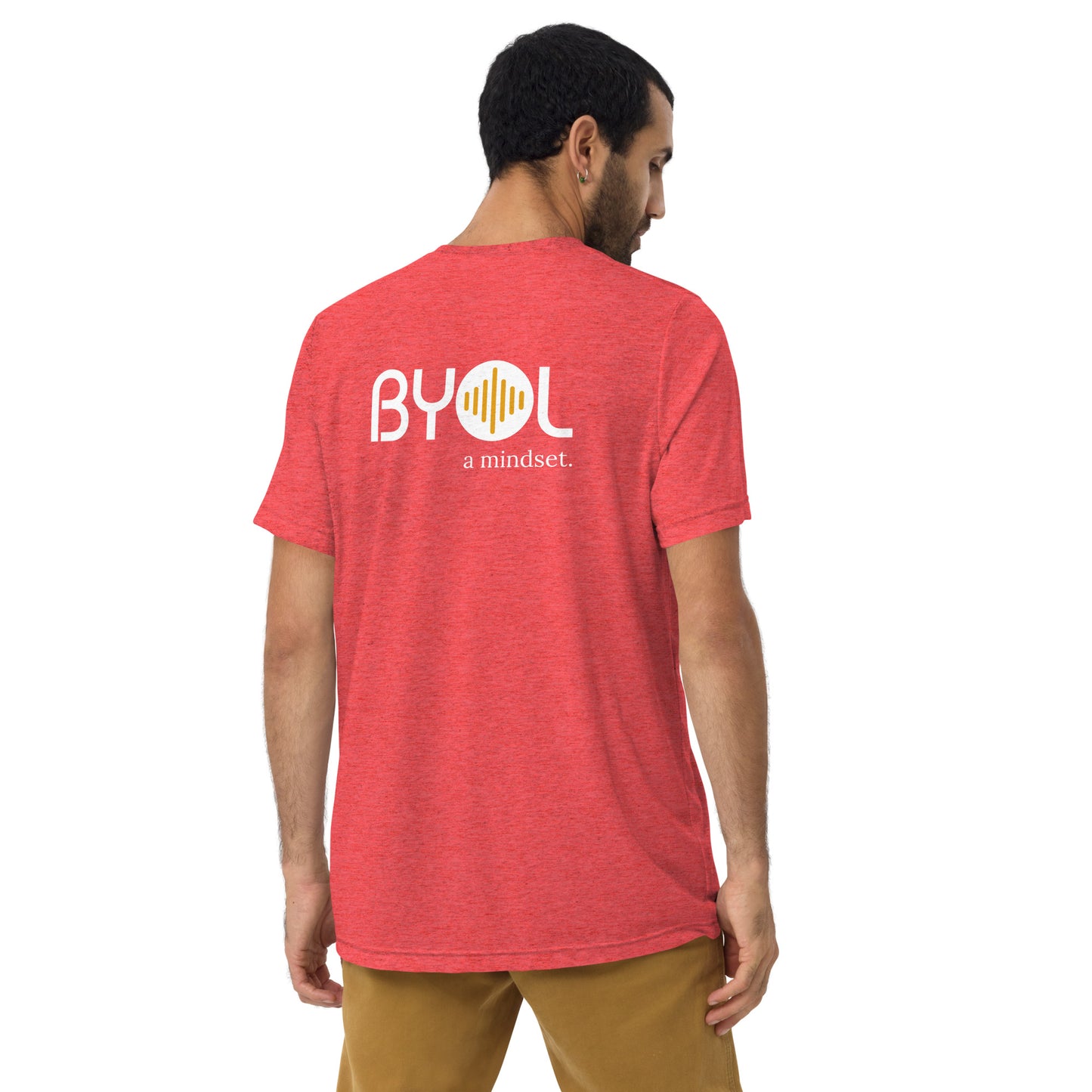 A young man with short dark hair wearing a red tri-blend "BYOL: a mindset" T-shirt, viewed from the back. The T-shirt features the "BYOL" logo in white and yellow on the back and is available in multiple colors (black, red, gray, pink, beige, plus more) and sizes (S-3XL). The "be you out loud" logo is displayed at the top.