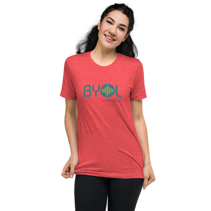 Woman wearing a red triblend BYOL mindset t-shirt with color options in black, red, pink, gray, and yellow, available in sizes S to 3XL.