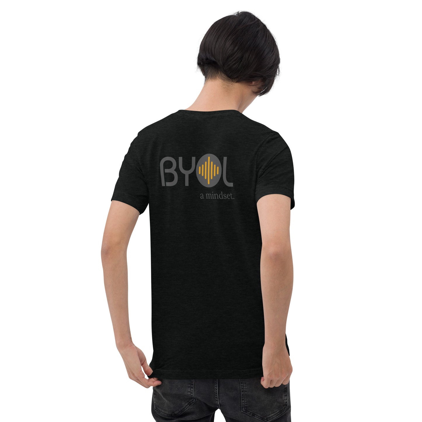 A young man with short black hair wearing a black tri-blend "BYOL: a mindset" T-shirt, viewed from the back. The T-shirt features the "BYOL" logo in black and yellow on the back and is available in multiple colors (black, red, gray, pink, gold, plus more) and sizes (S-3XL). The "be you out loud" logo is displayed at the top.