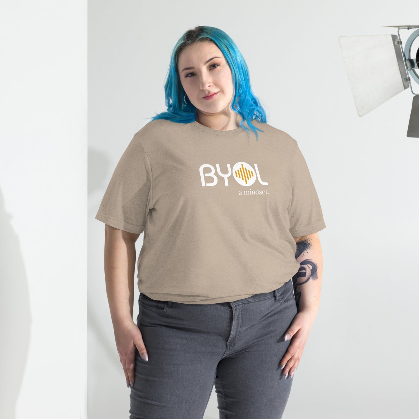 Woman wearing a loose fit BYOL mindset t-shirt in tan triblend with color options in black, red, pink, gray, and yellow, available in sizes S to 3XL.