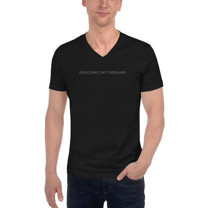 Man wearing a black v-neck tee with the text "Building My Dreams" 