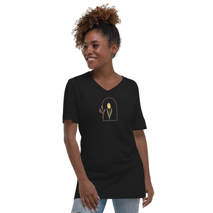 Woman wearing a black V-neck tee with a floral archway design, representing subtle elegance and authenticity.