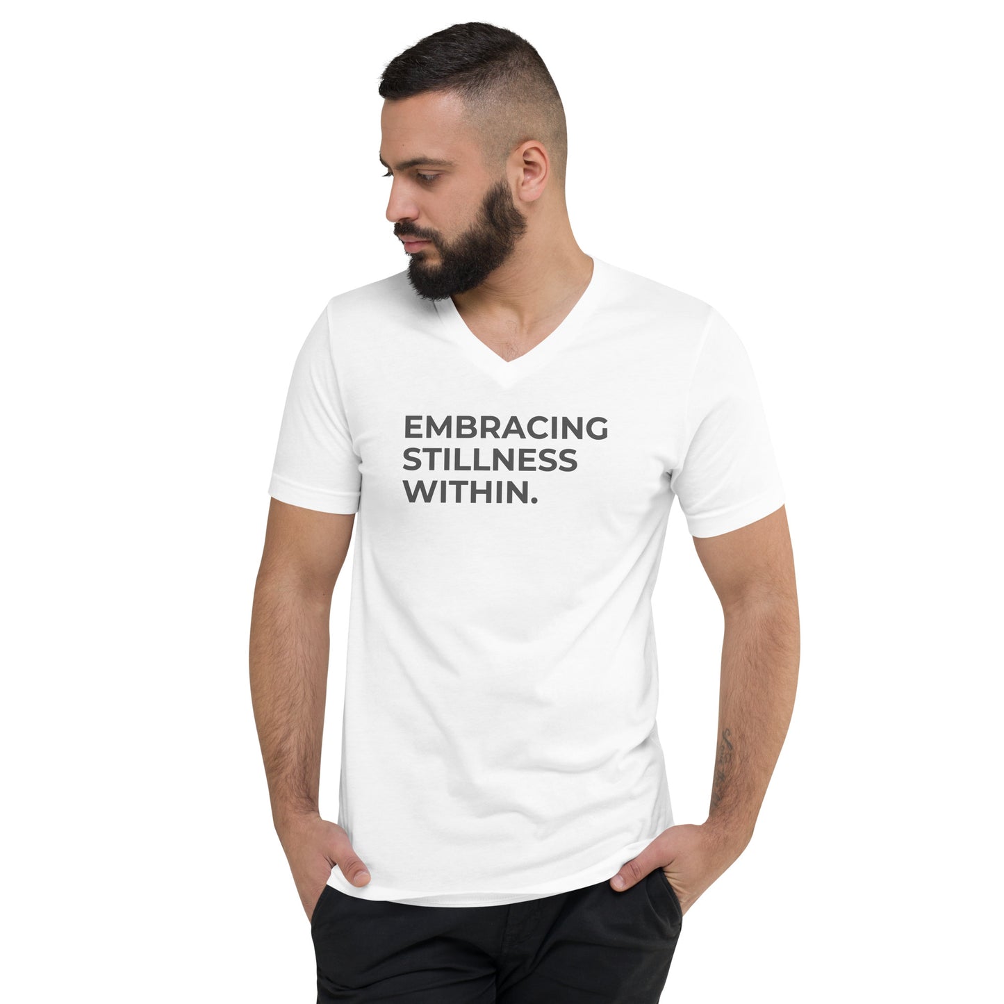 Man with a beard wearing a white v-neck tee with the text "Embracing Stillness Within".