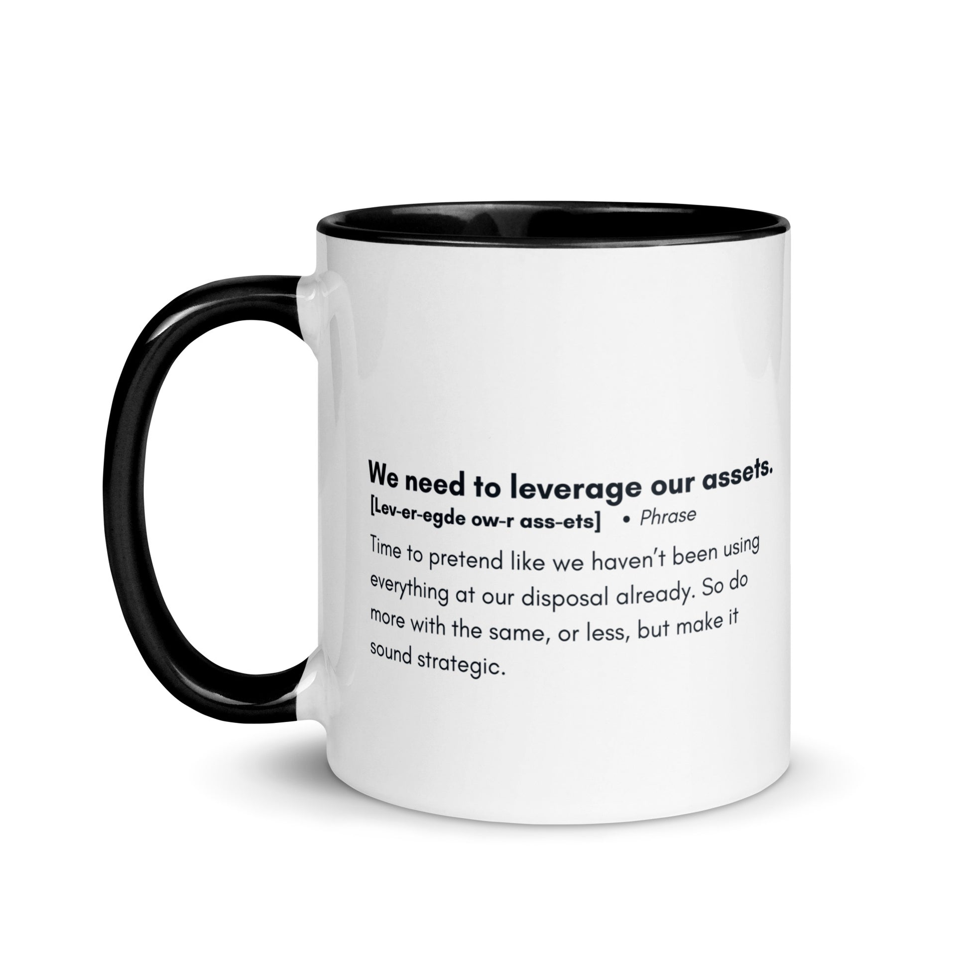 White ceramic mug with black inside and handle with the words, "We need to leverage our assets" followed by a humorous definition. 