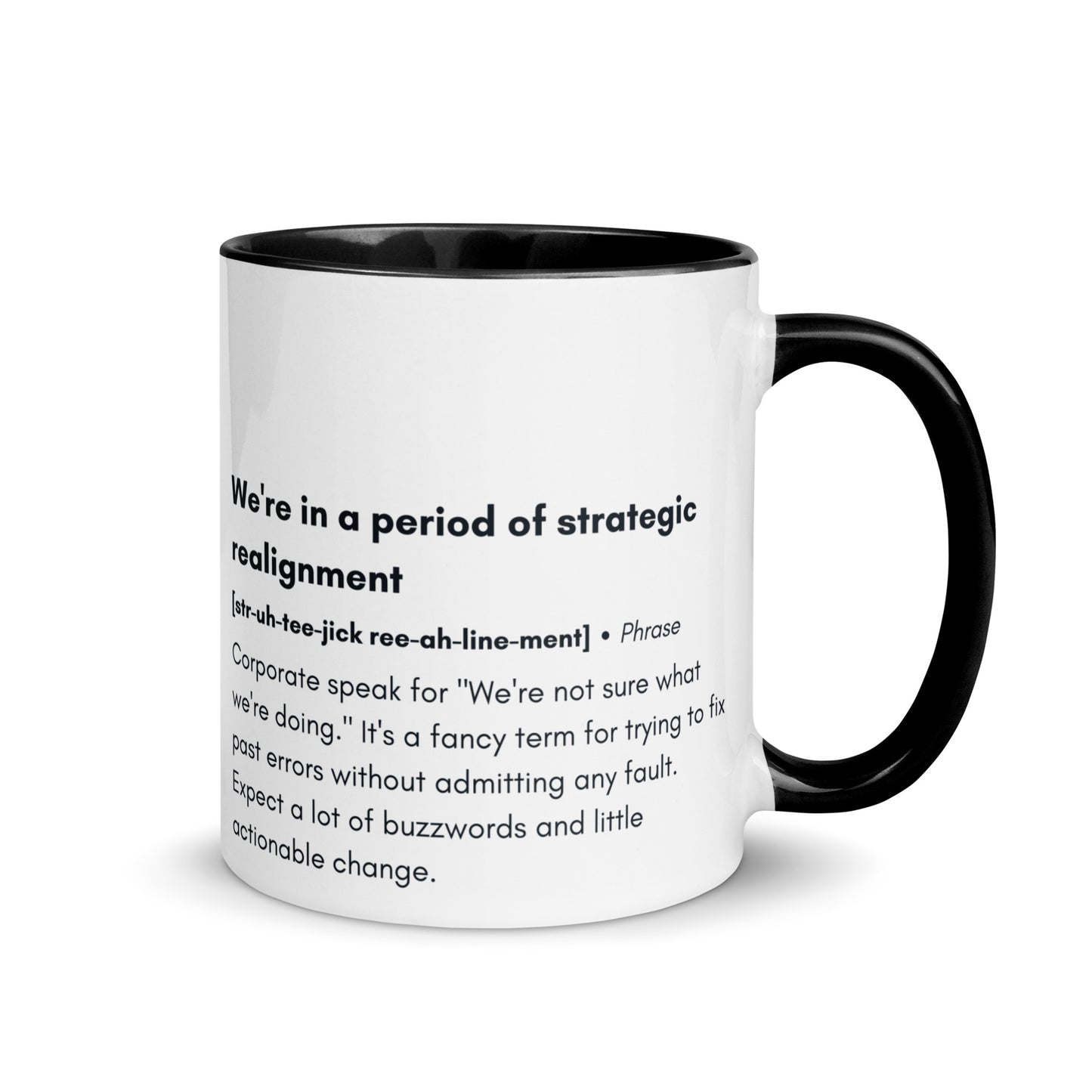 ceramic white mug with black inside and handle with the words "we're in a period of strategic realignment" with a humorous definition. 