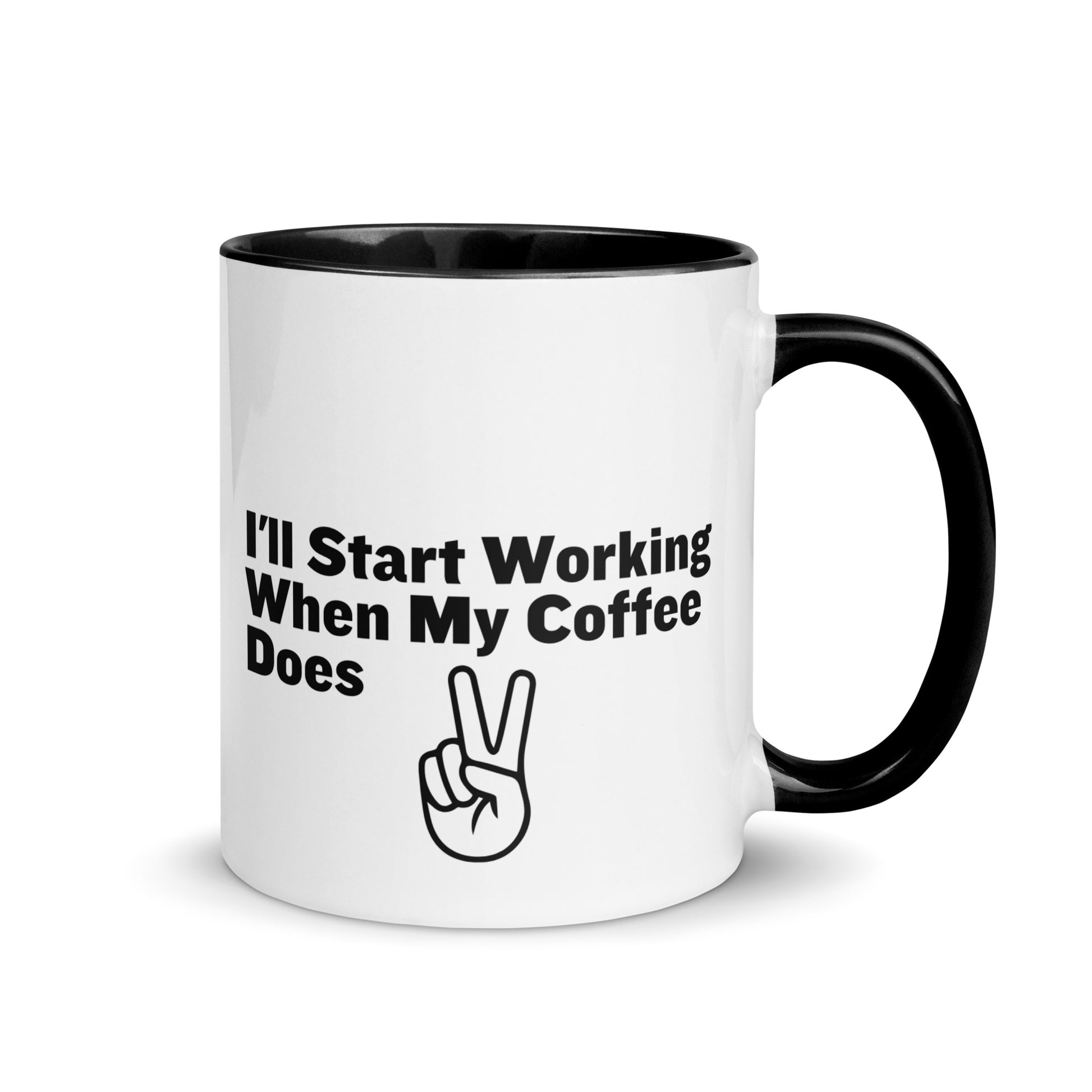 White ceramic mug with a black inside and handle with the words, "I'll start working when my coffee does"