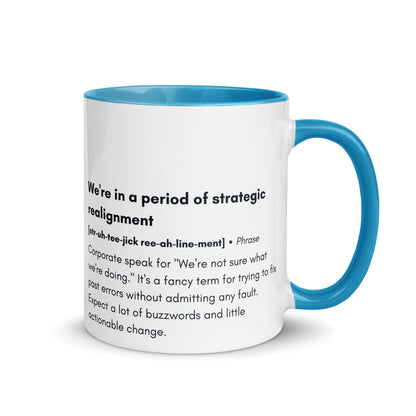 ceramic white mug with light blue inside and handle with the words "we're in a period of strategic realignment" with a humorous definition. 