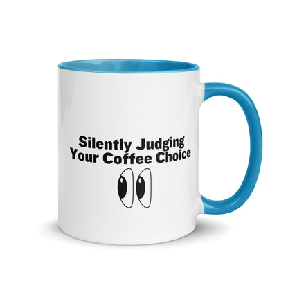 White ceramic mug with light blue inside and handle with the words, "Silently judging your coffee choice"