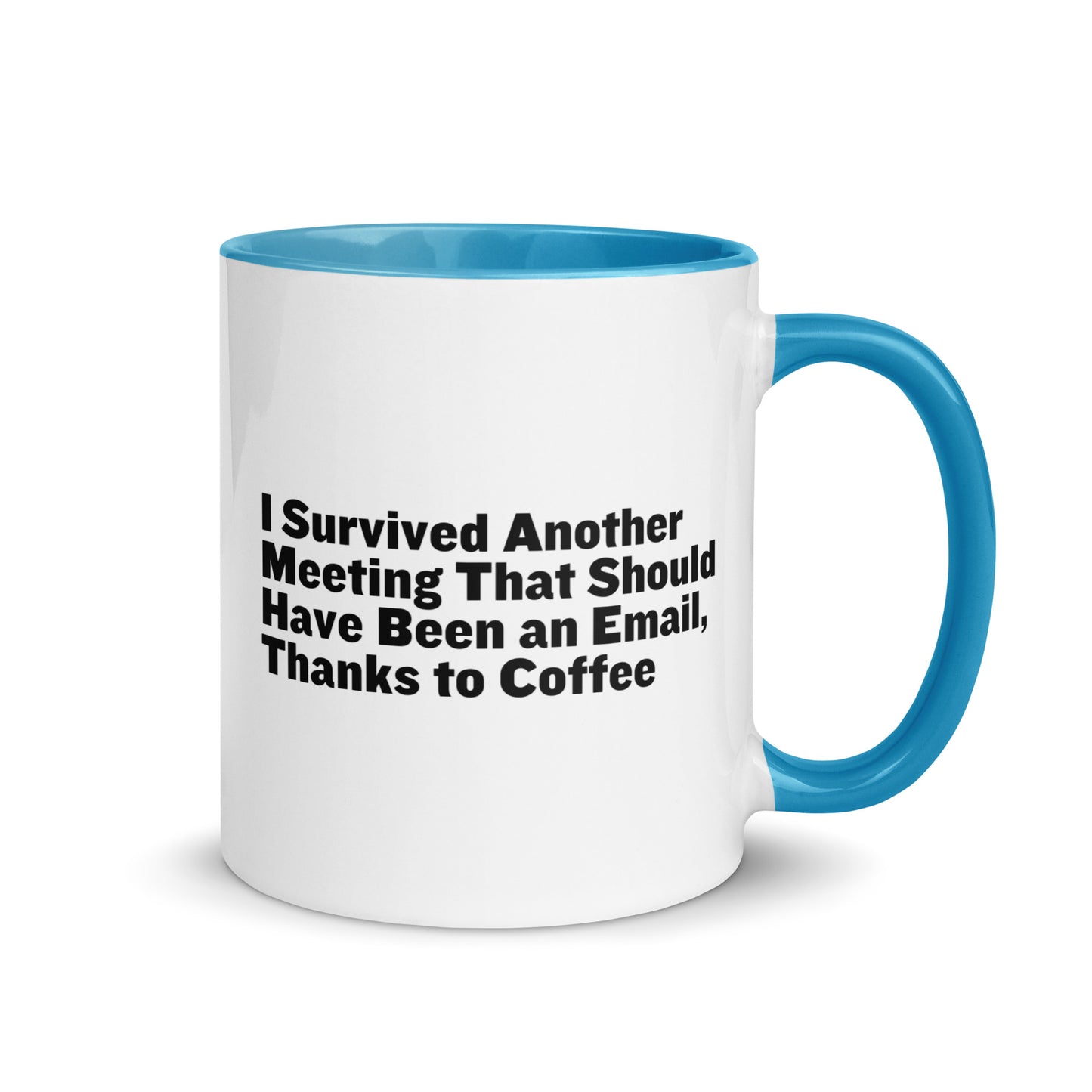 White ceramic mug with light blue inside and on the handle with words that say, "I survived another meeting that should have been an email, thanks to coffee"