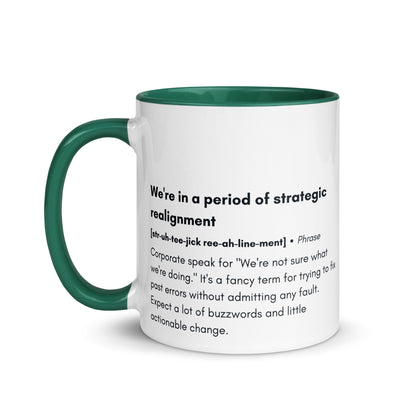 ceramic white mug with green inside and handle with the words "we're in a period of strategic realignment" with a humorous definition. 