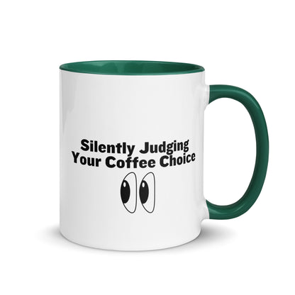 White ceramic mug with green inside and handle with the words, "Silently judging your coffee choice"