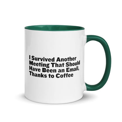 White ceramic mug with green inside and on the handle with words that say, "I survived another meeting that should have been an email, thanks to coffee"