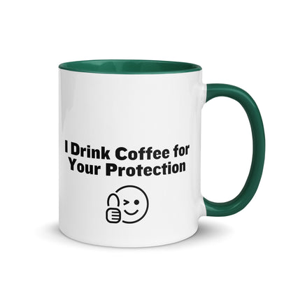 White ceramic mug that is green inside and on the handle with the words, "I drink coffee for your protection"