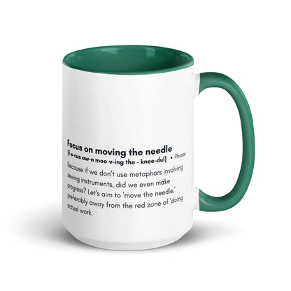 Ceramic white cup with dark green inside and handle with the words, "focus on moving the needle" followed by a humorous definition 