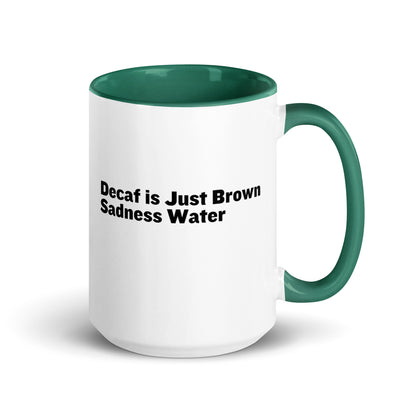 White ceramic mug with a green inside and handle with the words, "Decaf is just Brown Sadness water"