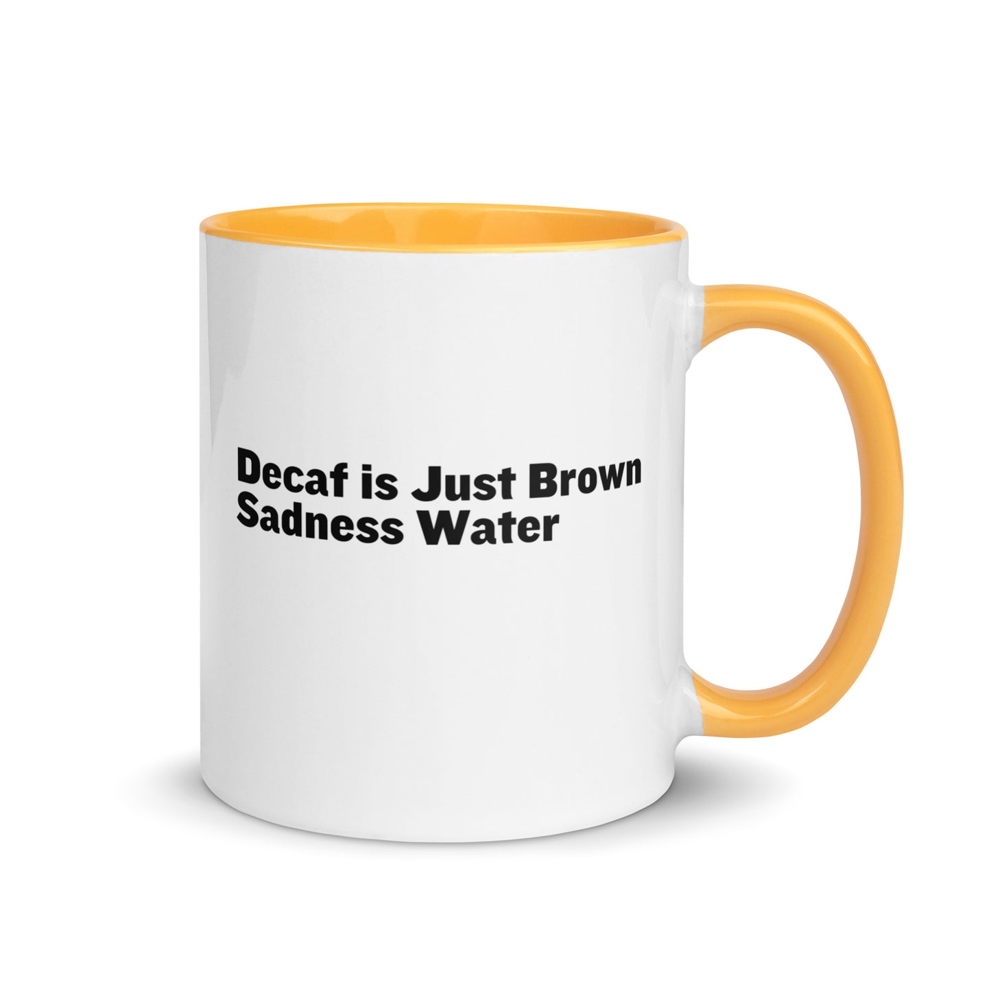 White ceramic mug with a golden yellow inside and handle with the words, "Decaf is just Brown Sadness water"