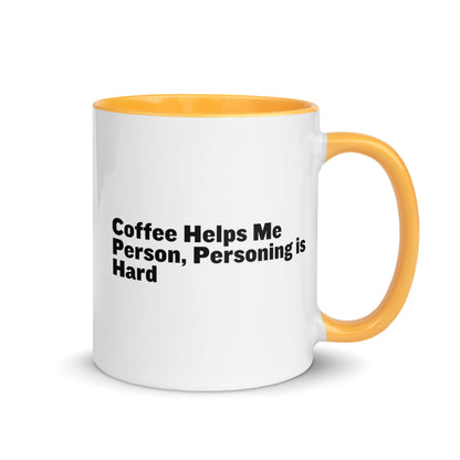 White ceramic mug with golden yellow inside and on the handle with the words, "Coffee helps me person, personing is hard"