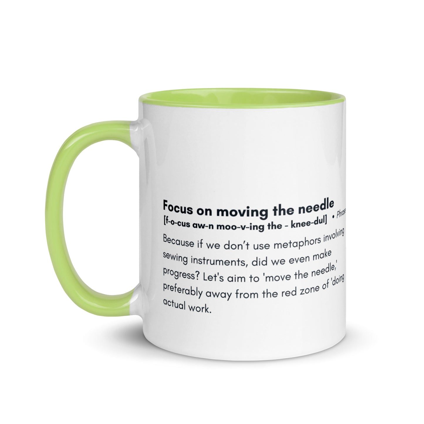 Ceramic white cup with light green inside and handle with the words, "focus on moving the needle" followed by a humorous definition 