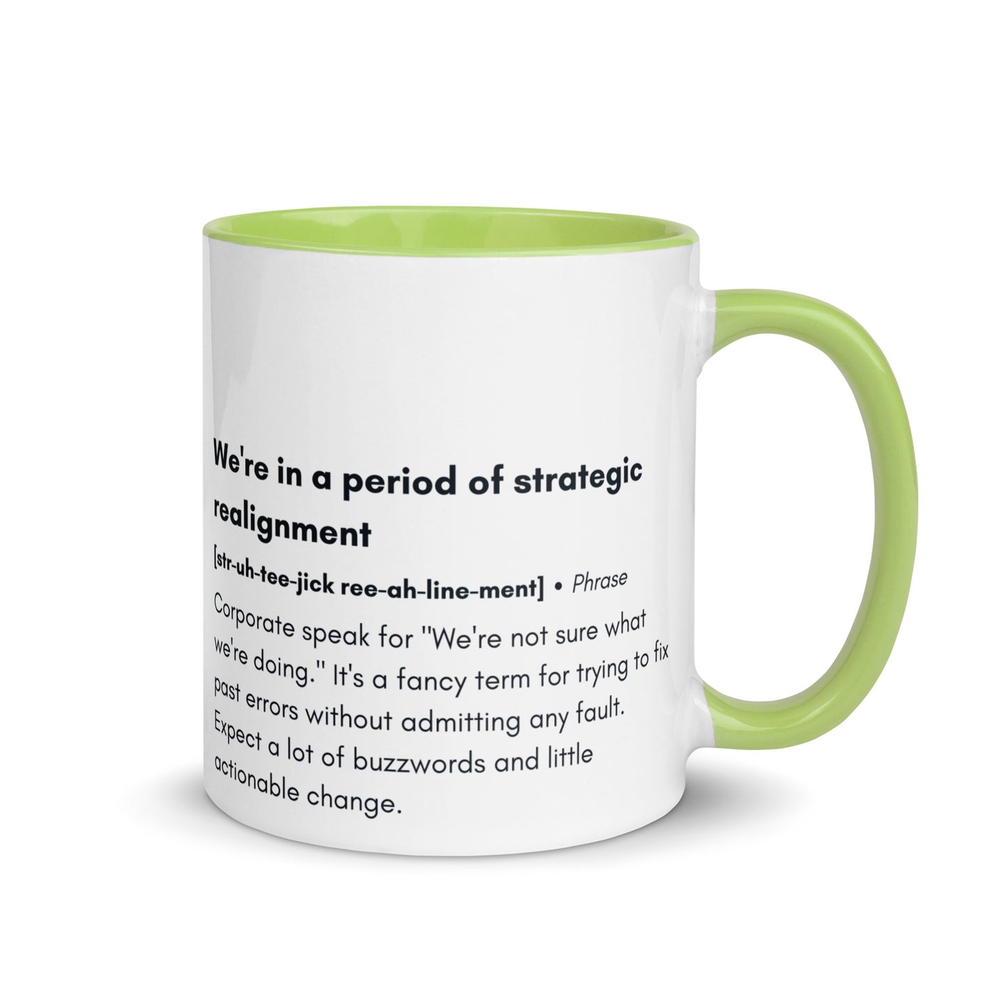 ceramic white mug with lime green inside and handle with the words "we're in a period of strategic realignment" with a humorous definition. 