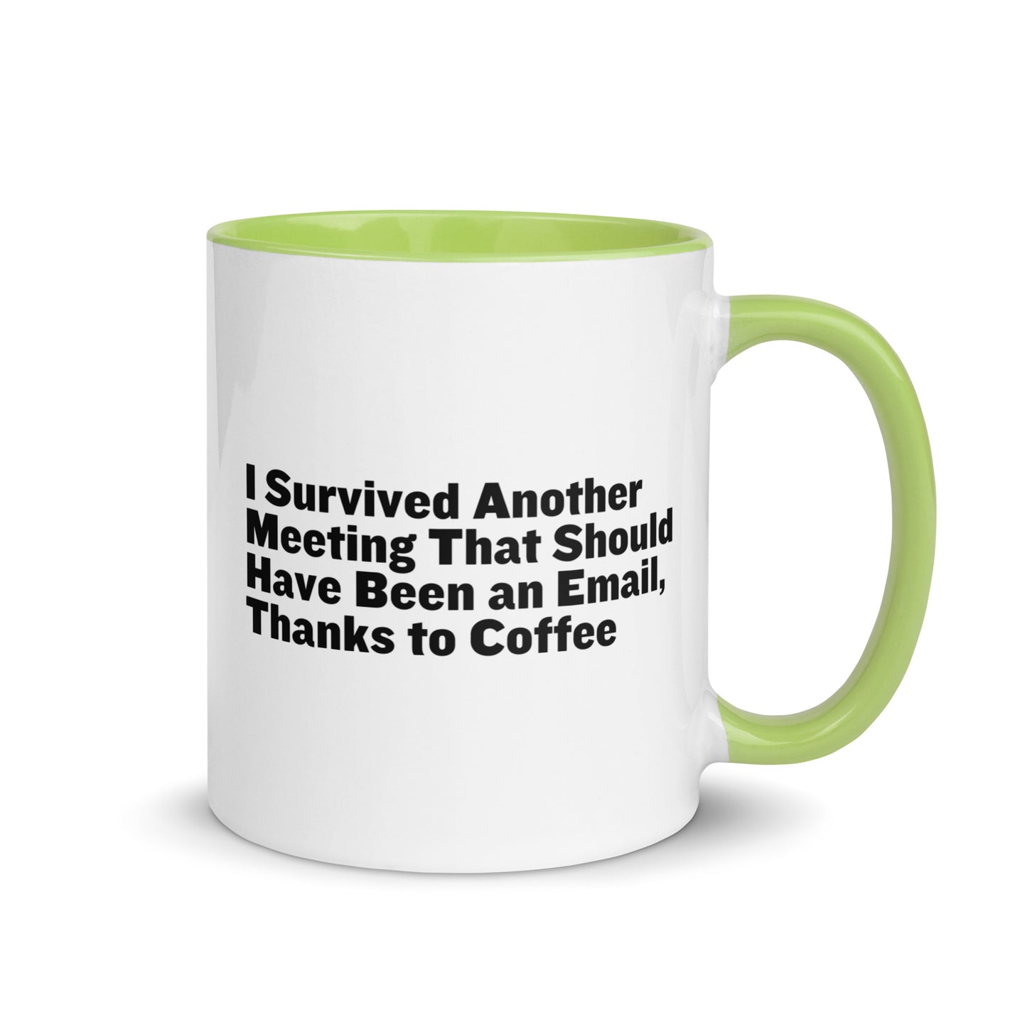 White ceramic mug with lime green inside and on the handle with words that say, "I survived another meeting that should have been an email, thanks to coffee"