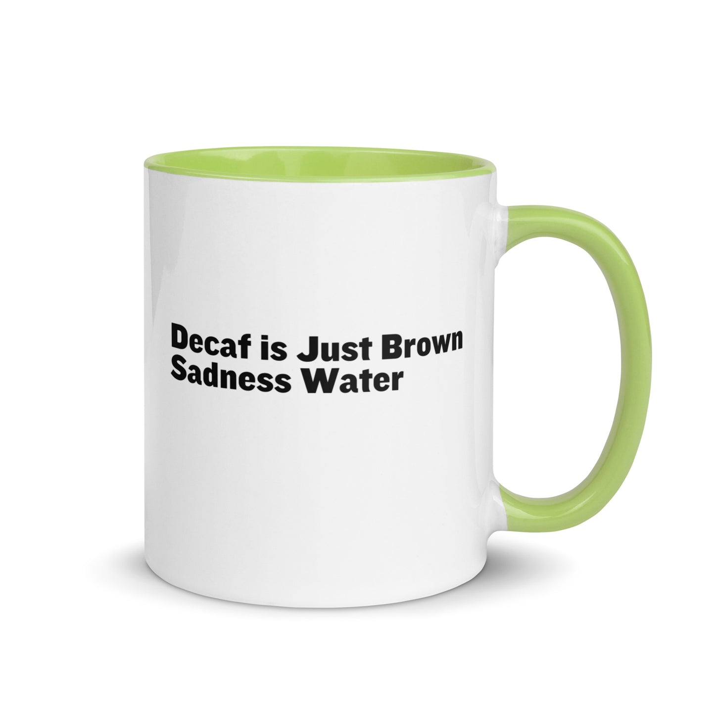 White ceramic mug with a lime green inside and handle with the words, "Decaf is just Brown Sadness water"