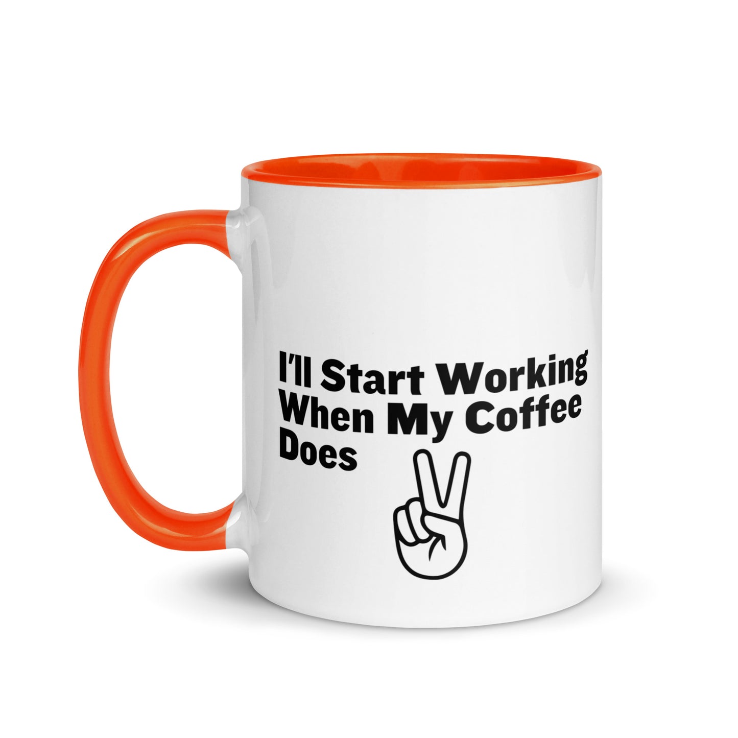 White ceramic mug with a orange inside and handle with the words, "I'll start working when my coffee does"