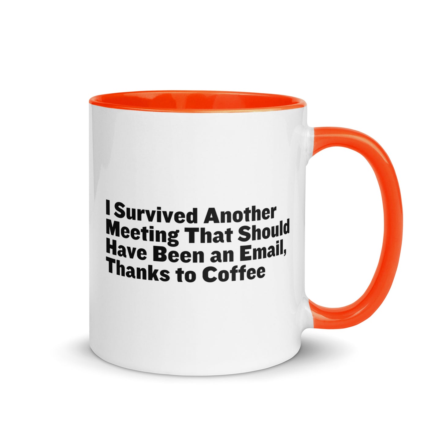 White ceramic mug with orange inside and on the handle with words that say, "I survived another meeting that should have been an email, thanks to coffee"