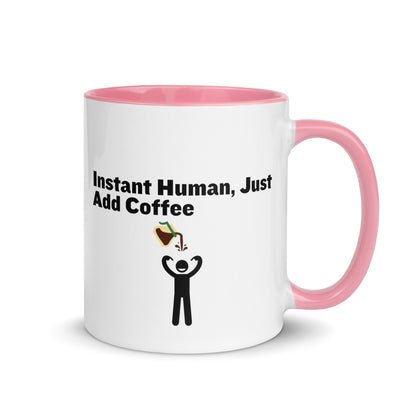 White ceramic mug with pink inside and handle with the words "Instant human, just add coffee"