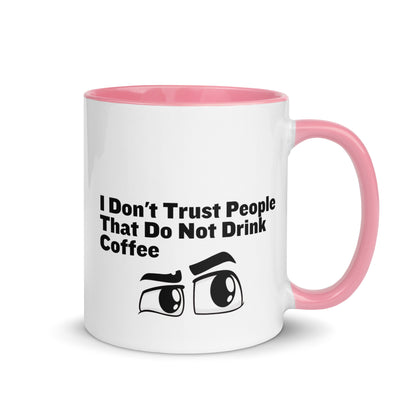 White ceramic mud with pink on the inside and on the handle with the words, "I don't trust people that do not drink coffee"