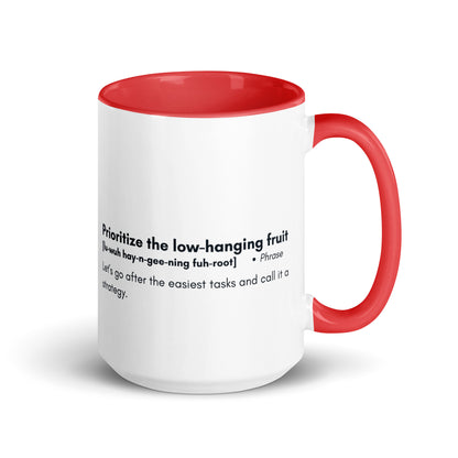 White ceramic mug with red inside and handle with words "Prioritize the low hanging fruit" followed by a humorous definition. 