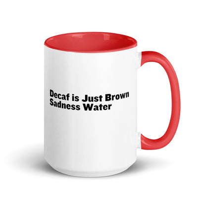 White ceramic mug with a red inside and handle with the words, "Decaf is just Brown Sadness water"