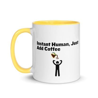 White ceramic mug with yellow inside and handle with the words "Instant human, just add coffee"