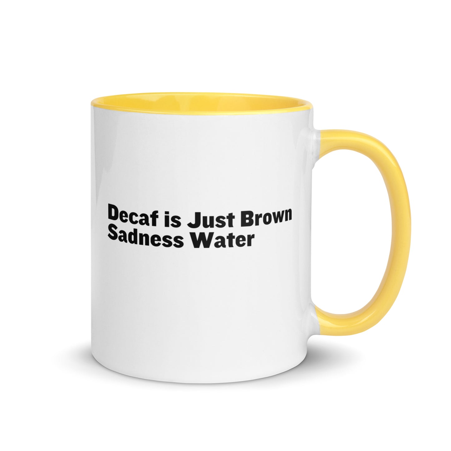 White ceramic mug with a yellow inside and handle with the words, "Decaf is just Brown Sadness water"