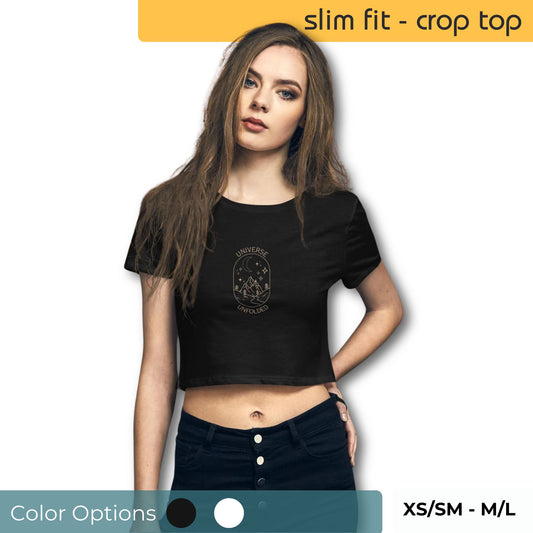 Woman in a black slim fit crop top with a 'Universe Unfolded' astrological design, paired with high-waisted jeans, available in sizes XS/SM to M/L.