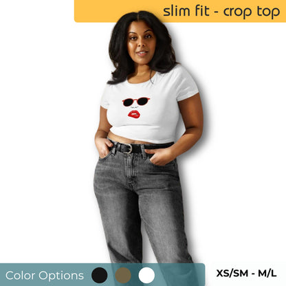 Confident woman in a white slim-fit crop top with red lip and sunglasses design, paired with high-waisted gray jeans, available in sizes XS/SM to M/L.