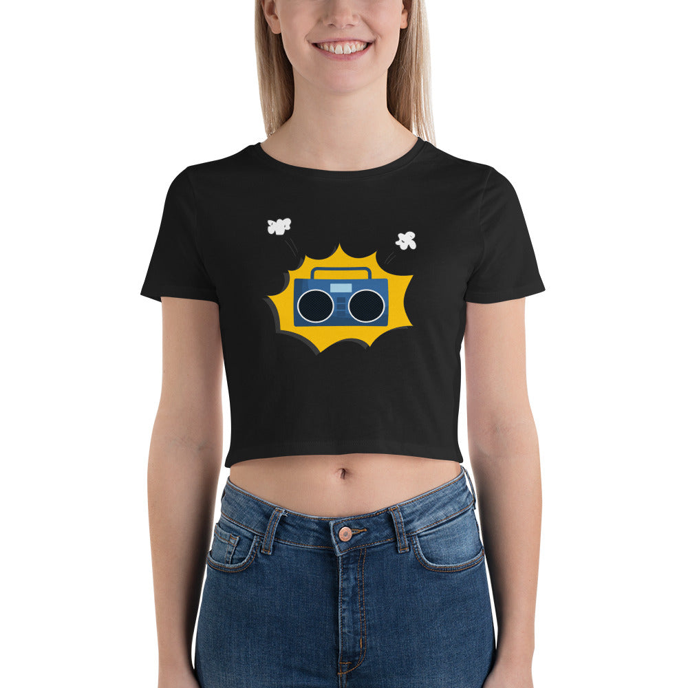 Smiling woman in a black crop top featuring a retro yellow boombox design with white accents.