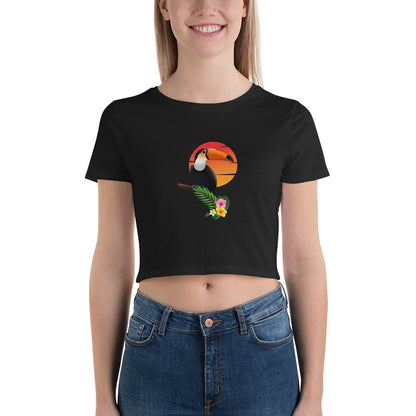 Joyful woman in a black crop top featuring a colorful toucan design against a sunset, perfect for a bold fashion statement.