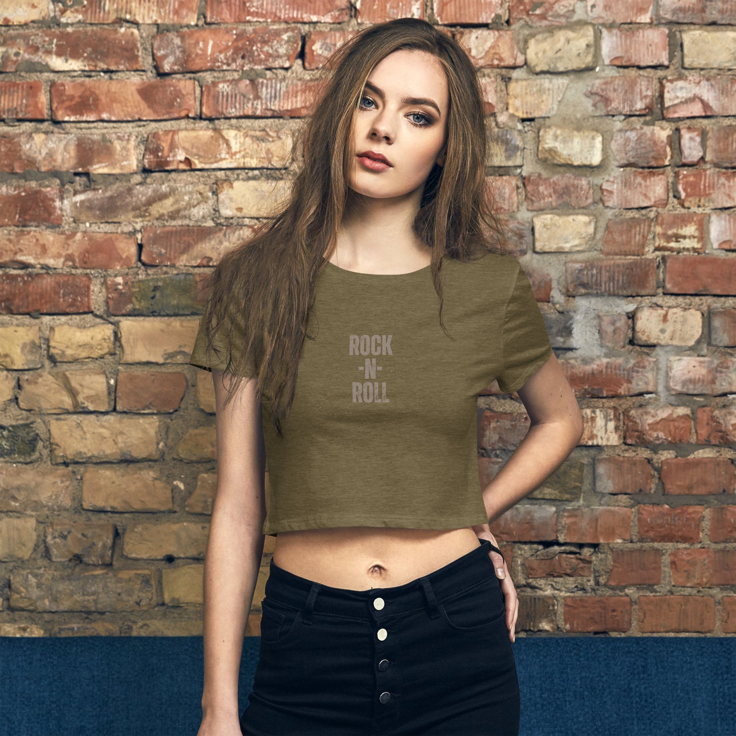 tylish woman wearing a heathered olive 'ROCK -N- ROLL' slogan crop top, combining classic rock edge with modern street style.