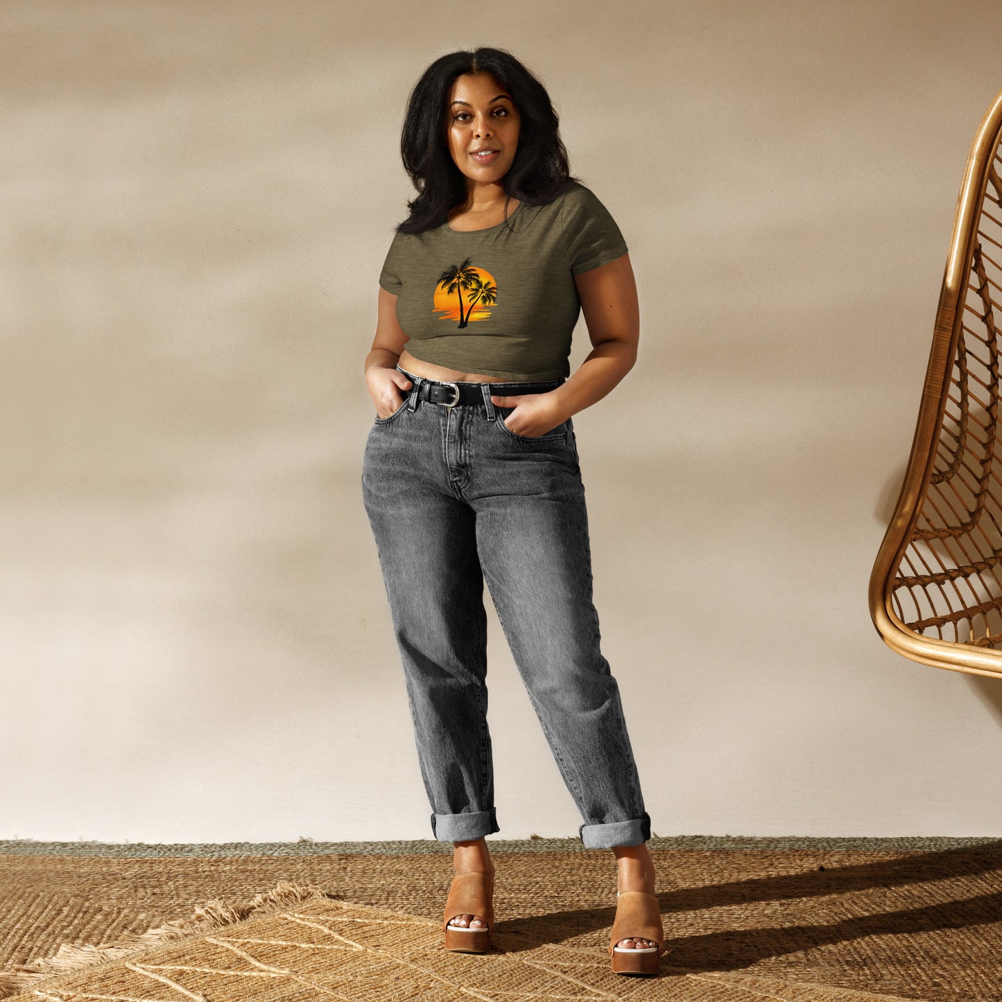 Woman in a heathered olive crop top featuring a sunset and palm trees design, embodying a relaxed and inspirational vibe.