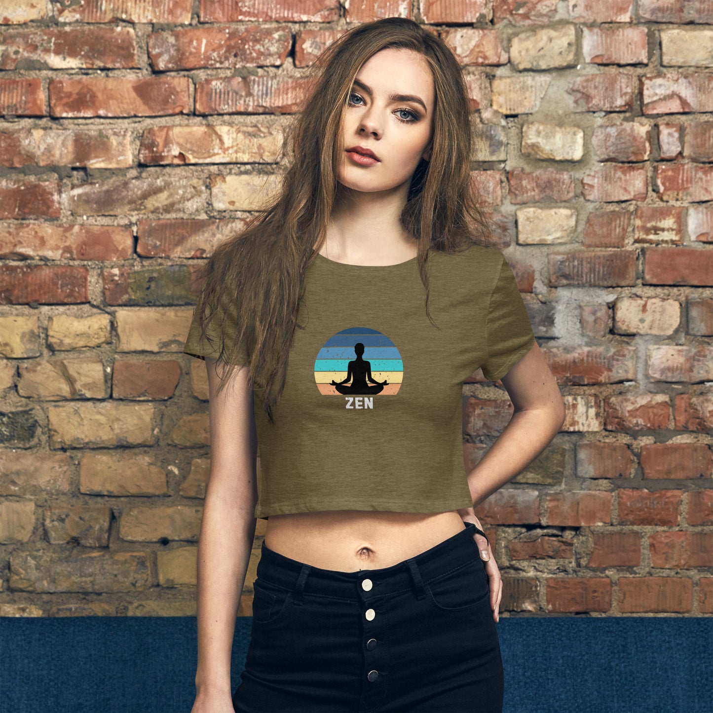 Poised woman in a heathered green crop top featuring a zen meditation graphic, merging style with a message of inner peace.