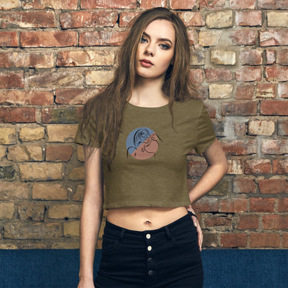 A woman in a olive green slim fit crop top with an artistic silhouette design. 