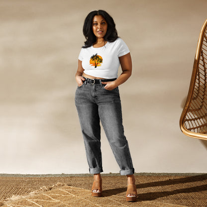 Woman in a white crop top featuring a sunset and palm trees design, embodying a relaxed and inspirational vibe.