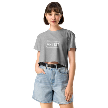 Confident young woman in a grey empowering crop top with the word 'ARTIST' printed in white.